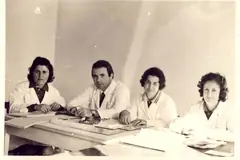Katër punonjës shëndetësorë rreth një tavoline, fotografi arkivi